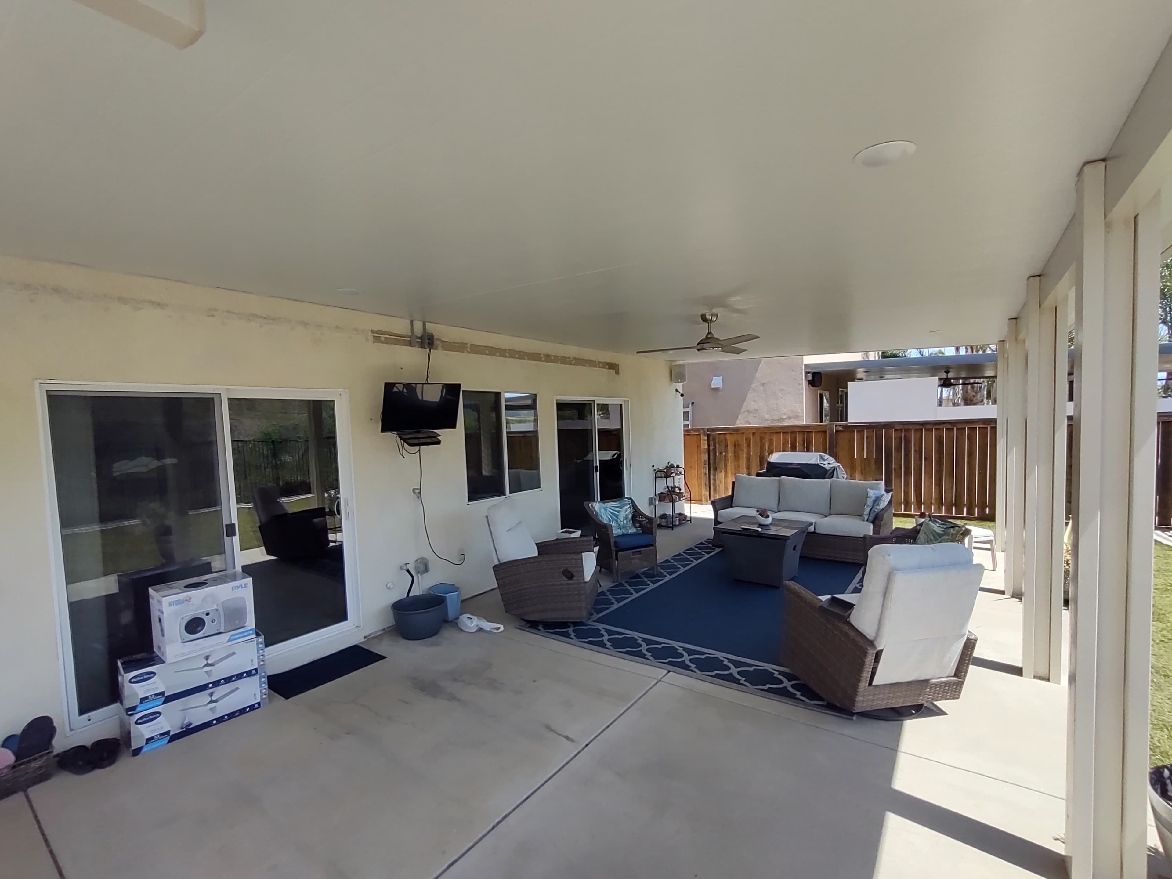 Aluminum patio cover with wood-grain finish over backyard seating